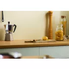 Ivory Satin Cladding installed above a wooden kitchen worktop. The surface is holding a chopping board, glass storage jars and a coffee percolator.