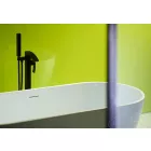 Lime Gloss Cladding installed in a bathroom  showing a white bath which is reflected in the cladding behind it, part  of a dry shower screen on the left.