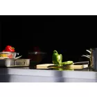 Slate Gloss Cladding installed above a stainless steel kitchen worktop. The surface is holding a chopping board, pans, utensils and various colourful peppers.
