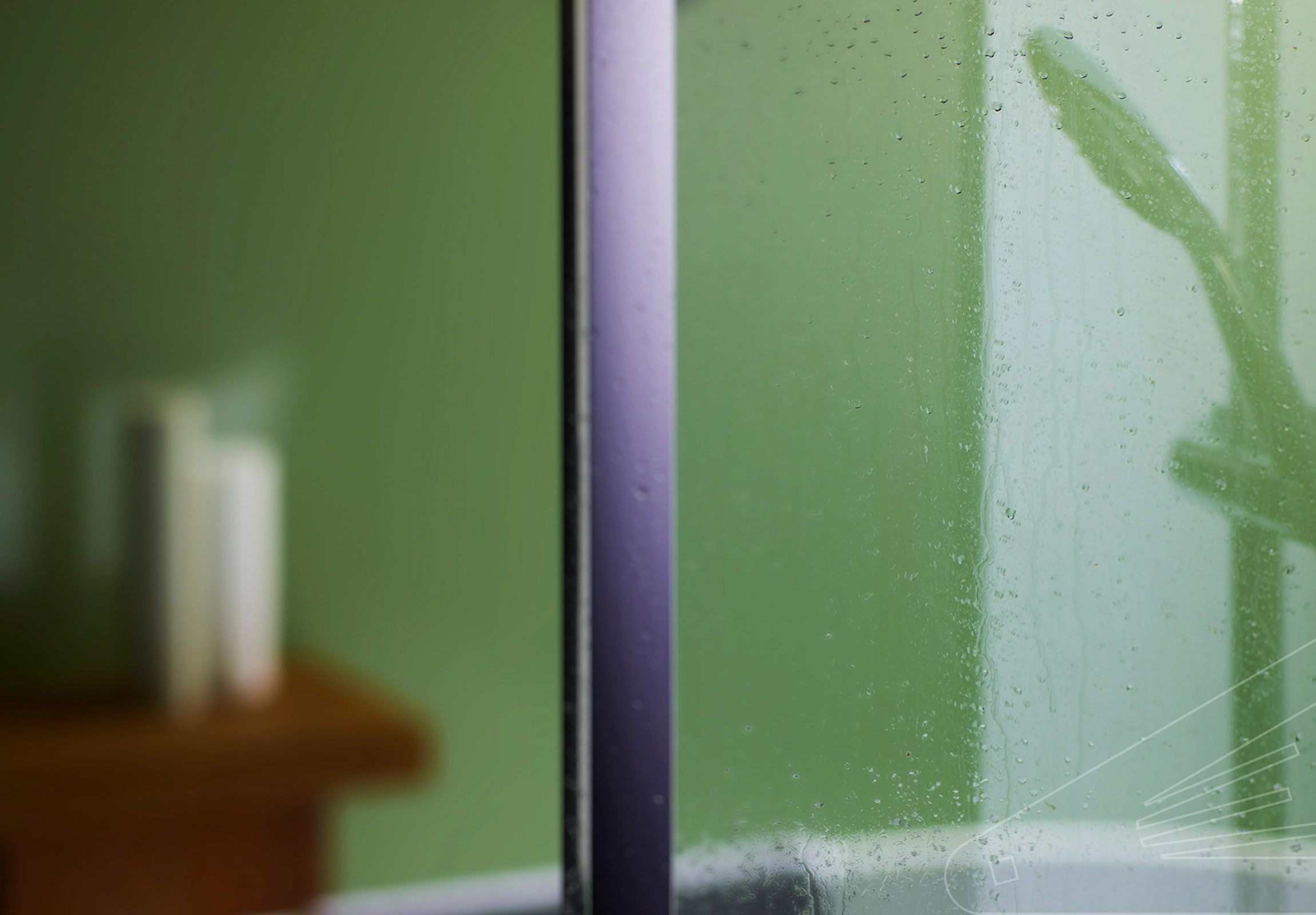 Avocado Gloss Cladding installed in a bathroom showing a still wet shower screen and reflection of shower head in the cladding.