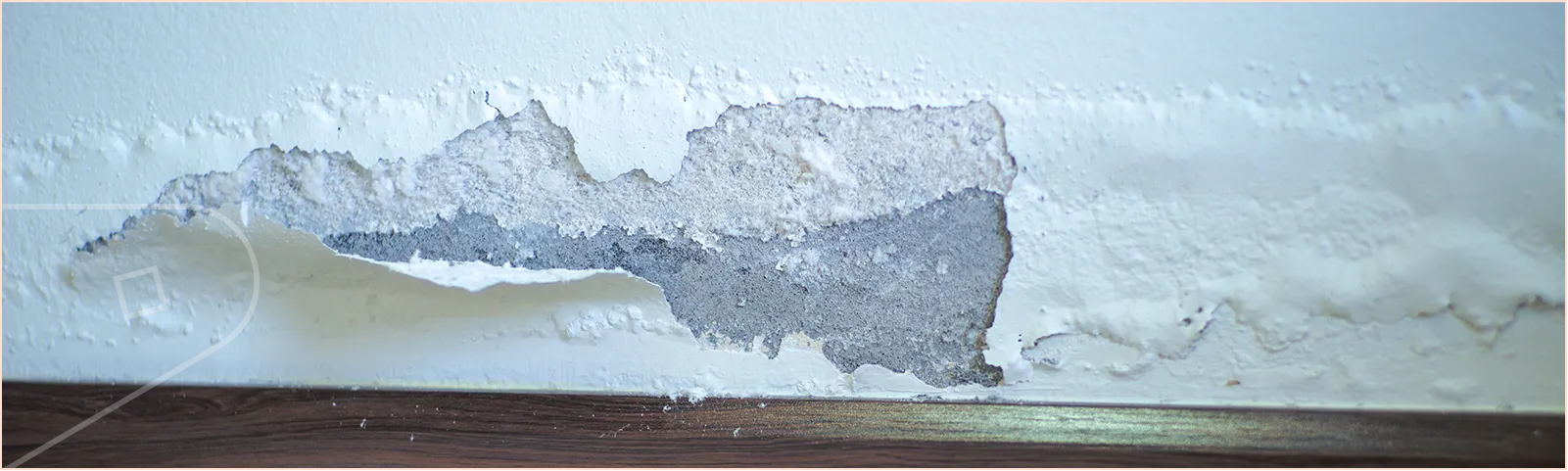 Wall with damaged paint, flaking and bubbling from damp.