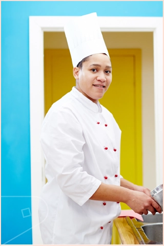 Chef in chef whites washing pots in kitchen with bright blue atlantic wall cladding