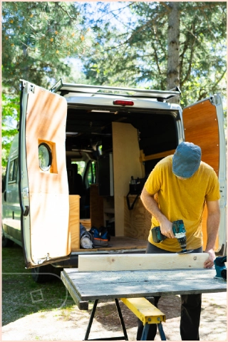 Man outside van that is being converted into a camper