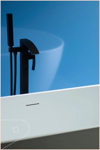 Bathroom scReen showing Bold Blue Lagoon Gloss plastic cladding behind white oval freestanding bathtub with matt black tap and a metal trimed shower screen
