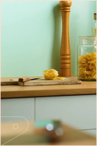Willow Satin Cladding installed in above a wood coloured Kitchen Worktop with Glass Jar's and Pepper Grinder
