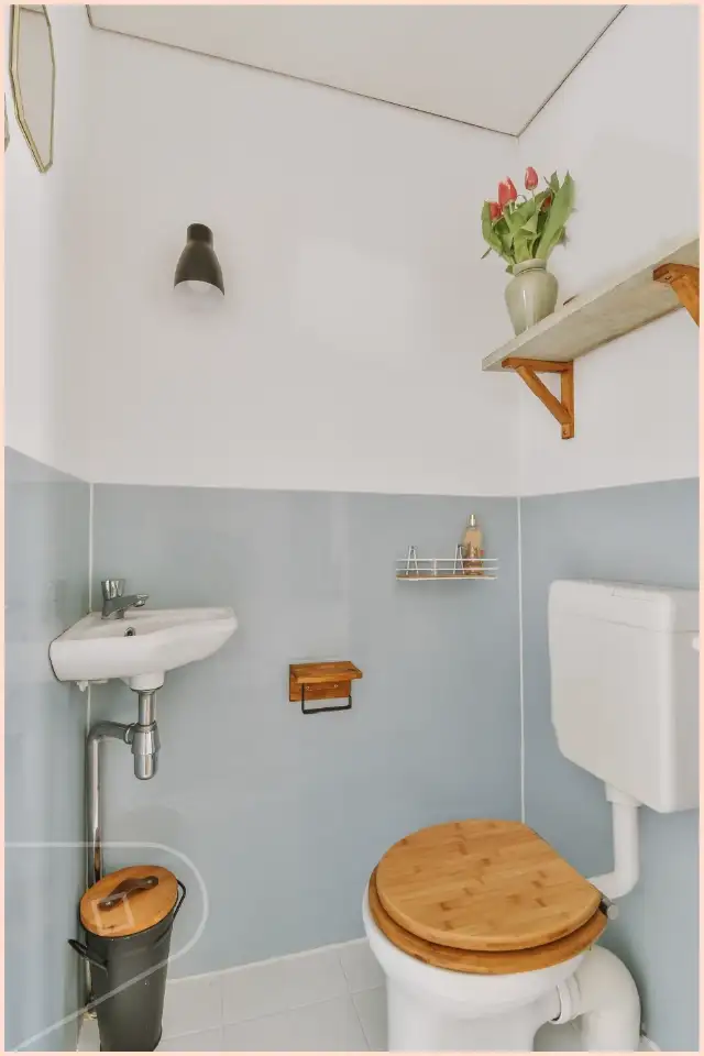 Small under stairs toilet with sky blue uPVC cladding half way up wall.